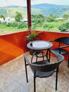 a table and two chairs on a porch with a view at apartamento equipado in Amatitlán