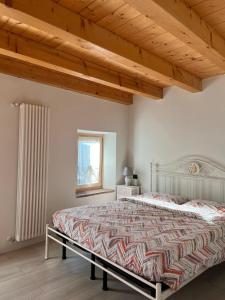 ネグラールにあるPiccolo Borgoの木製の天井が特徴のベッドルーム1室(大型ベッド1台付)