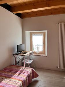 a bedroom with a desk and a computer in a window at Piccolo Borgo in Negrar