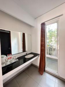 a bathroom with a sink and a window at Hotel Ompu Herti in Balige