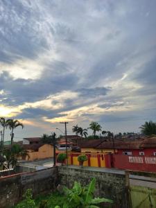 een bewolkte hemel met palmbomen en gebouwen bij Casa Bairro Belas Artes in Itanhaém