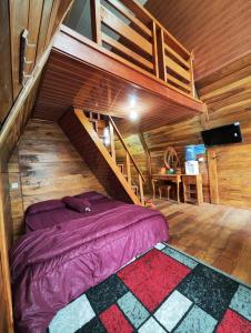 - une chambre avec un lit dans une maison en bois dans l'établissement Golden Orchid Villa, à Diyeng