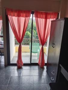 an open door with red curtains in a room at ซิตี้ แม่นชั่น in Ban Ai Dao