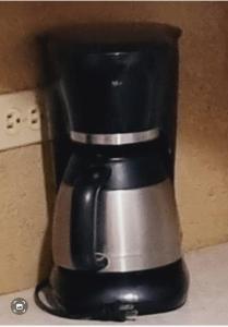 a black coffee maker sitting on top of a counter at apartamento equipado in Amatitlán