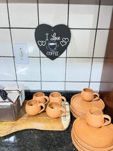 un grupo de tazas y platos en un mostrador de cocina en Casa para família e amigos, en Soure
