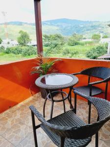 2 sillas y una mesa en un porche con vistas en apartamento equipado en Amatitlán