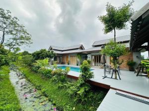 a house with a swimming pool and a garden at Greyhouse Homestay 