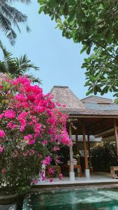 a house with pink flowers next to a swimming pool at Villa Sally in Canggu