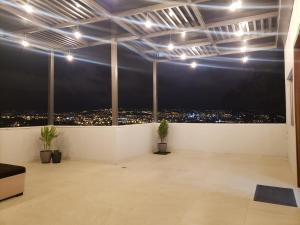 Cette chambre offre une vue sur la ville la nuit. dans l'établissement Departamento completo con hermosa vista de la ciudad, à Cuenca