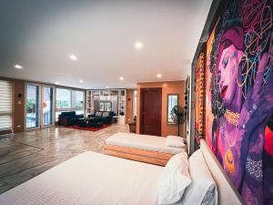 Wazobia Boracay في بوراكاي: غرفة نوم بسريرين ولوحة على الحائط