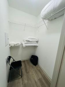 a small room with a chair and a bed and towels at Peaceful apartment in Frisco