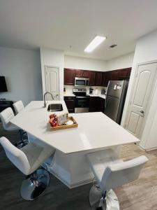 a kitchen with a white table and two white chairs at Peaceful apartment in Frisco