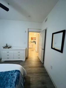 a white bedroom with a bed and a hallway at Peaceful apartment in Frisco