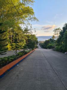 une rue vide avec des arbres sur le côté de la route dans l'établissement Rotunda Inn home stay, à Pagadian