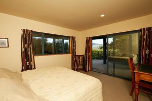 Tempat tidur dalam kamar di Akaroa holiday home Spacious and quite with stunning harbour views and close to town