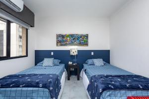 um quarto com duas camas e um quadro na parede em LFlats no Hotel Aeroporto Congonhas em São Paulo