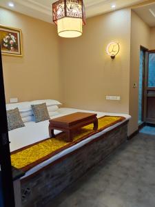 Un dormitorio con una cama con una mesa. en Pingyao hu lu wa Home Inn, en Pingyao
