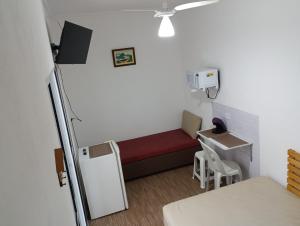 Habitación pequeña con cama y mesa pequeña. en Suíte Independente - Praia Indaiá e Riviera - MarDoceLar Bertioga, en Bertioga