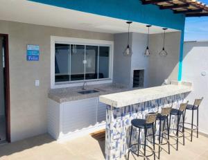 a kitchen with a bar with stools at Casa de Praia - Búzios in Búzios