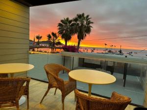 two tables and chairs on a balcony with a view of the beach at Nolana hotel in Taltal