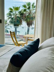 a bedroom with a view of a table and palm trees at Nolana hotel in Taltal