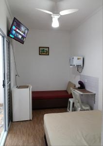 um quarto de hospital com uma cama e uma televisão na parede em Suíte Independente - Praia Indaiá e Riviera - MarDoceLar Bertioga em Bertioga