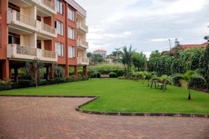 un patio de un edificio de apartamentos con césped en Brand New Condo Apartment en Kampala