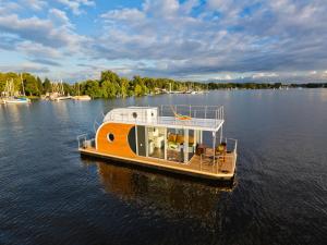 een klein bootje drijvend op een grote hoeveelheid water bij Houseboat on the Dahme in Niederlehme