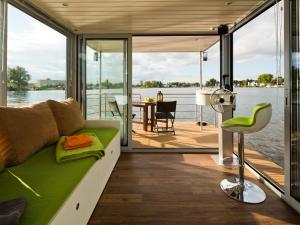 a living room with a green couch and a view of the water at Houseboat on the Dahme in Niederlehme