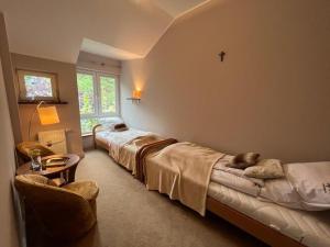 a bedroom with two beds and a table and a window at Holiday house with sauna and garden, Pobierowo in Pobierowo