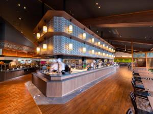 a restaurant with a bar with people sitting at it at Yukai Resort Premium Koshinoyu in Nachikatsuura