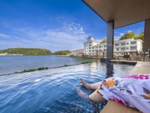 那智勝浦的住宿－Yukai Resort Premium Koshinoyu，躺在水边游泳池边的女人