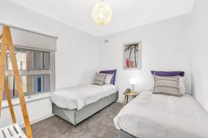 a bedroom with two beds and a window at Beachtown Breeze - A Coastal Gem in Glenelg East in Glenelg