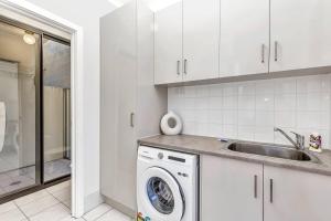 a kitchen with a washing machine and a sink at Stellar - Spacious Rooftop Dreamscape in Adelaide in Rose Park