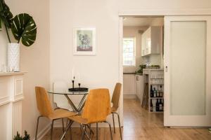 a dining room with a glass table and chairs at Cranbrook Courtyard - A Sunny City-fringe Retreat in Wayville