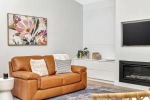 uma sala de estar com um sofá de couro castanho e uma televisão em 'Chimney Cottage' Family Gem where Beach meets Port em Birkenhead