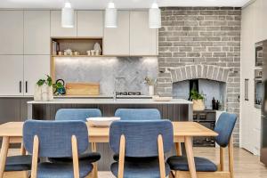 a kitchen with a wooden table and blue chairs at 'Chimney Cottage' Family Gem where Beach meets Port in Adelaide