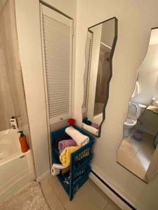 a bathroom with a mirror and a chair in front of a sink at Beautiful two bedroom apartment. in Calgary