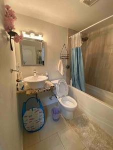 a bathroom with a sink and a toilet and a mirror at Beautiful two bedroom apartment. in Calgary