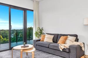 een woonkamer met een bank en een tafel bij 'The Outlook' Light-filled Nordic Contemporary in Glenunga