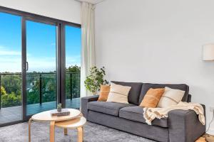 a living room with a couch and a table at 'The Outlook' Light-filled Nordic Contemporary in Adelaide