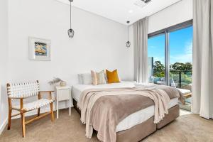 een witte slaapkamer met een bed en een raam bij 'The Outlook' Light-filled Nordic Contemporary in Glenunga