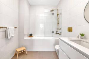 a bathroom with a tub and a toilet and a sink at 'The Outlook' Light-filled Nordic Contemporary in Adelaide +11 photos