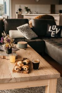 a coffee table with a tray of pastries on it at The Lake House Meadowbank: Waterfront Retreat in Ellendale