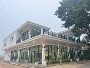 DM Hotel & Cafe في Ban Na Tho: مبنى أبيض كبير مع شرفة فوقه