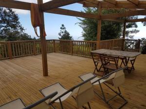 une terrasse en bois avec une table et des chaises. dans l'établissement TAMPON - Villa au calme,Vue Panoramique, SPA,SAUNA, à Le Tampon