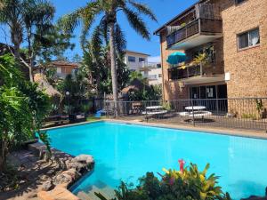 a swimming pool in front of a building at Reef Resort Apartments in Mona Vale