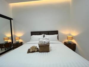 DM Hotel & Cafe في Ban Na Tho: سرير مع سلة من المناشف ودبي عليه