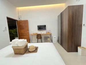 Ban Na Tho的住宿－DM Hotel & Cafe，客房设有一张带桌子和椅子的床。