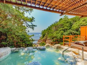 an outdoor hot tub with a view of the ocean at Yukai Resort Premium Hotel Senjo in Shirahama